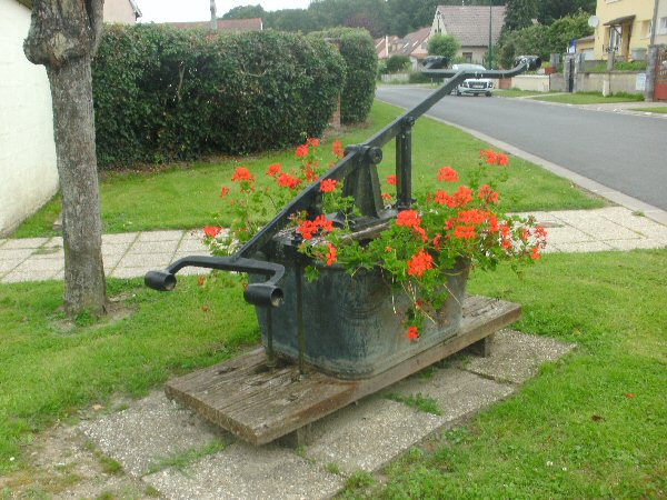 Oude pompierspomp als bloemenbak